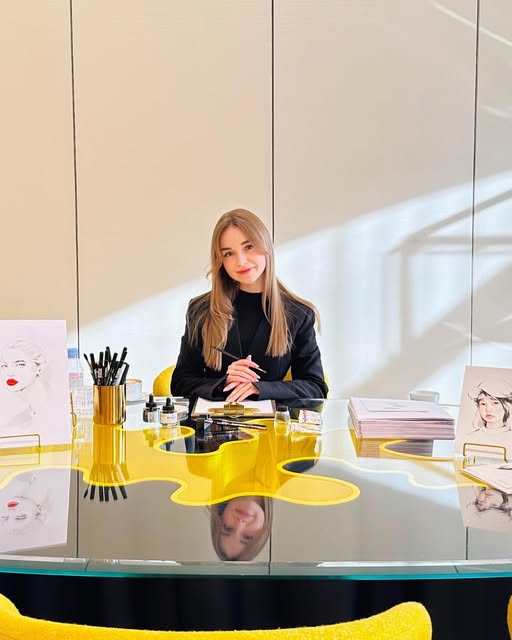 Olga Nikitina at her illustration desk with brushes and portraits